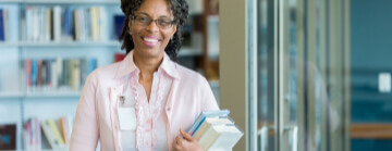 Librarian smiling and holding books